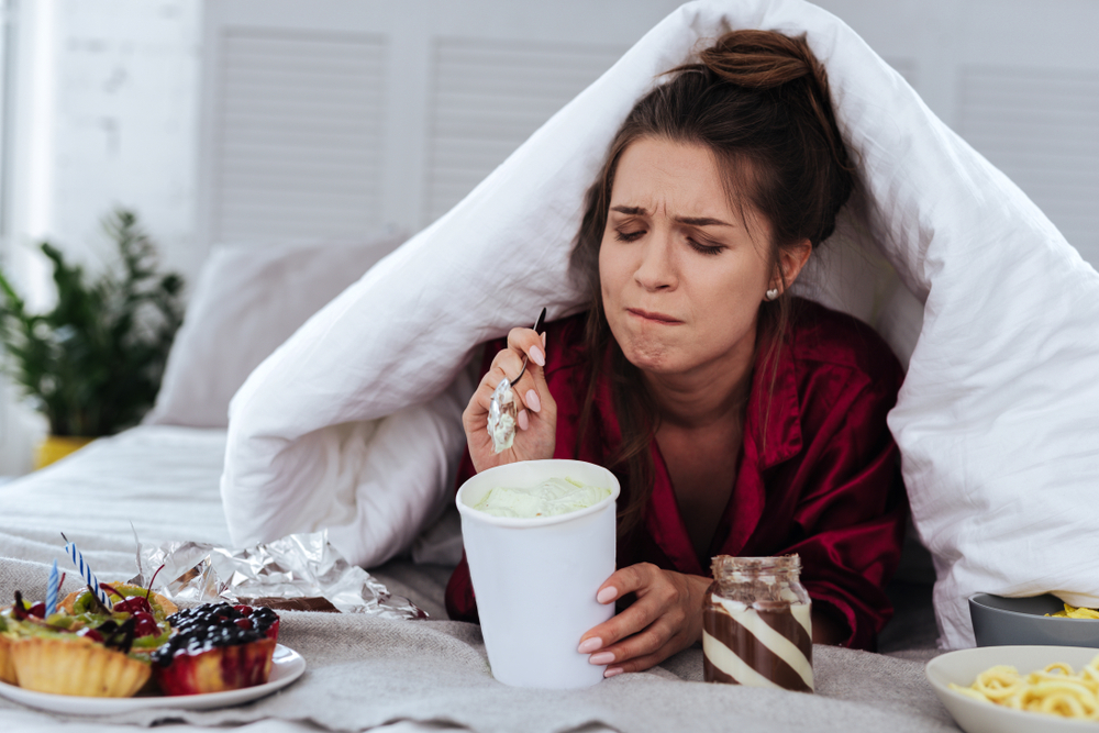 woman eating in bed beat hangover with workout and nutrition tips