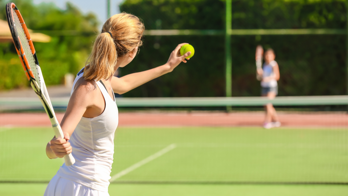 woman serving in tennis beginner playing tennis