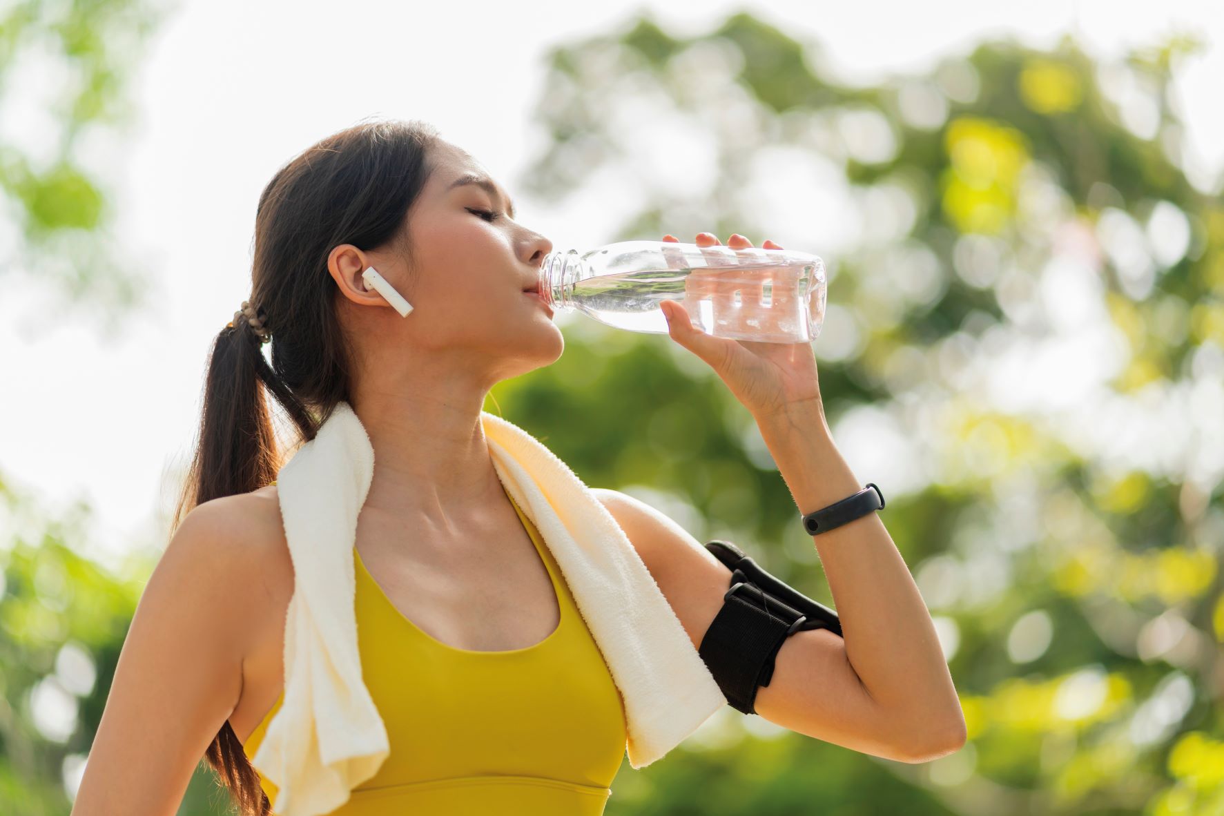 woman drinking water during uk heatwave to exercise safely in hot weather