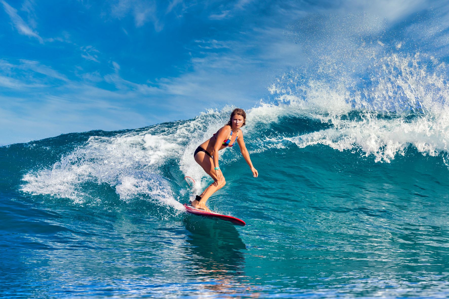 woman surfing on a wave during a surfing retreat