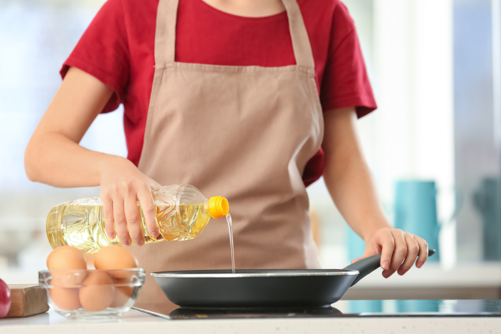 woman cooking with healthy oil in kitchen