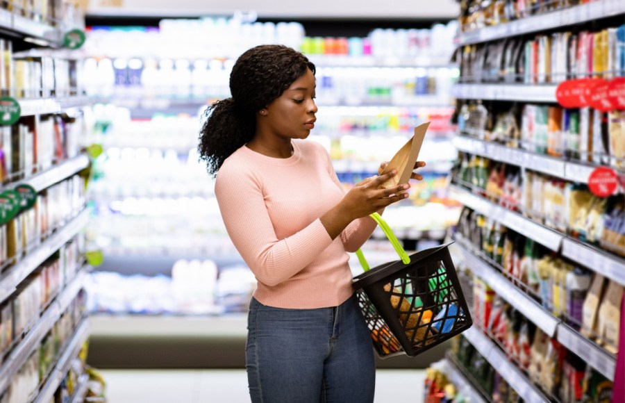 woman reading food product labels in supermarket