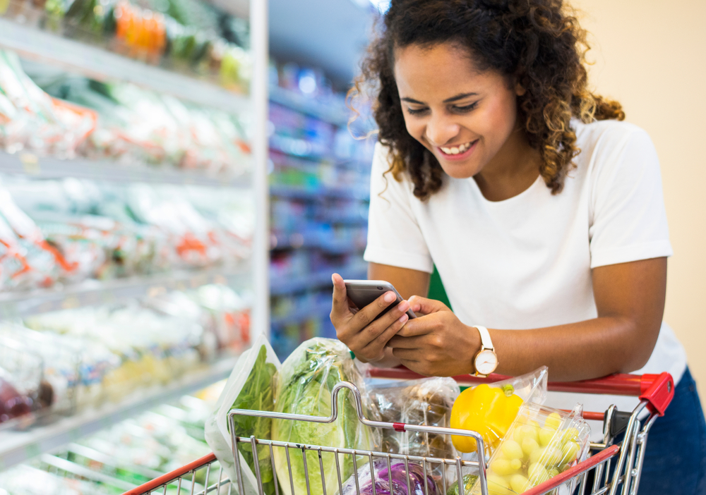 woman following healthy grocery shopping list at supermarket