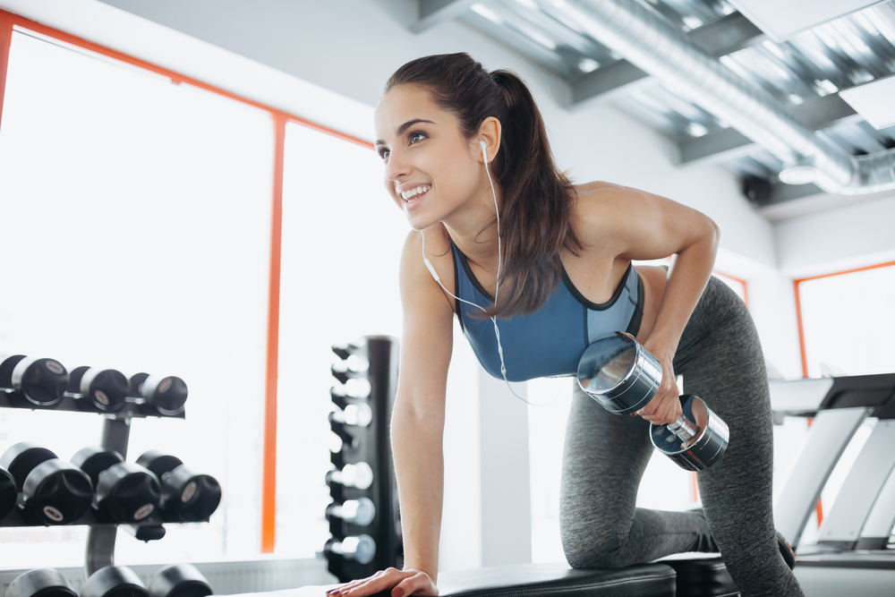 woman at gym doing short workouts with dumbbells