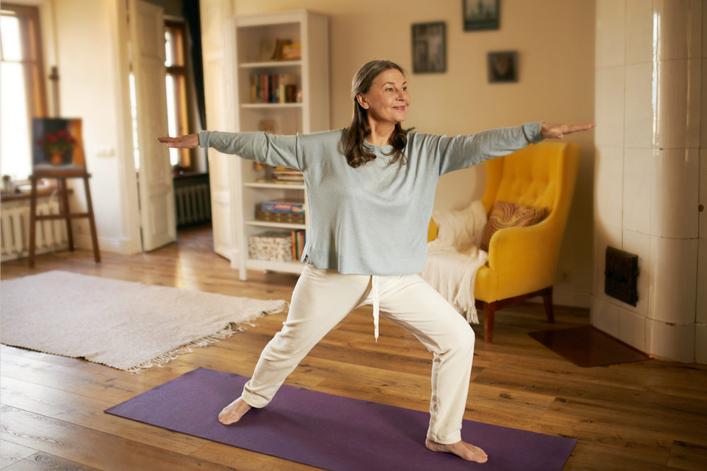 mature woman practicing yoga at home