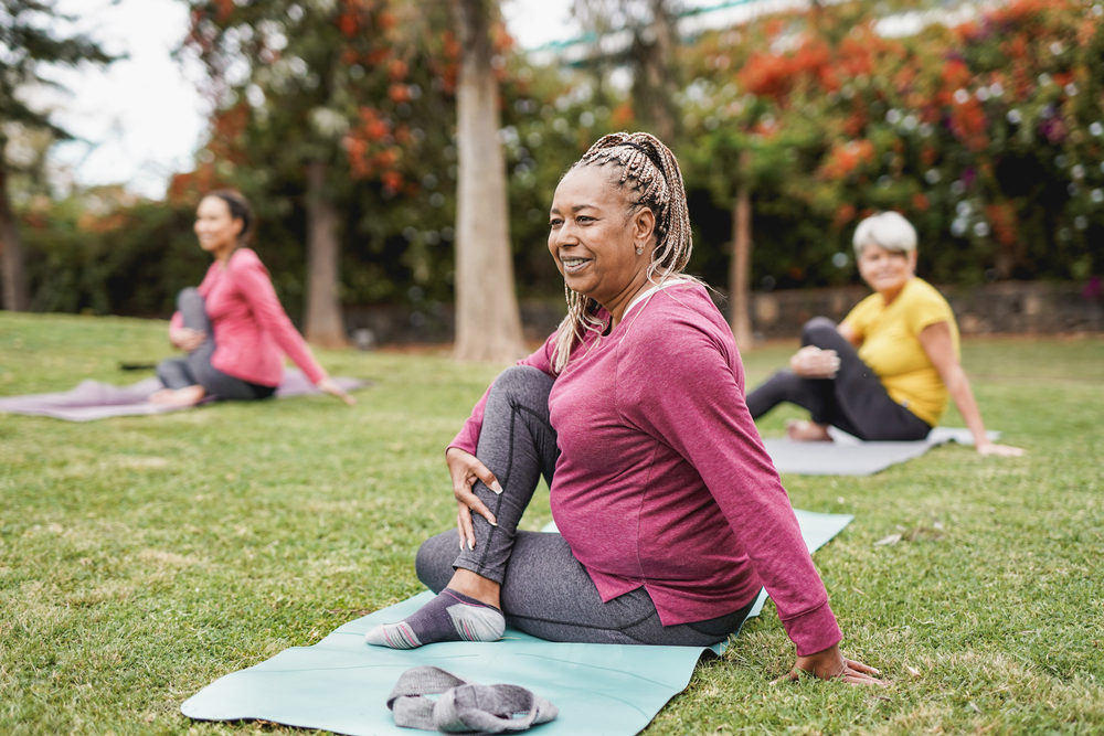 mature women exercising yoga class outdoors