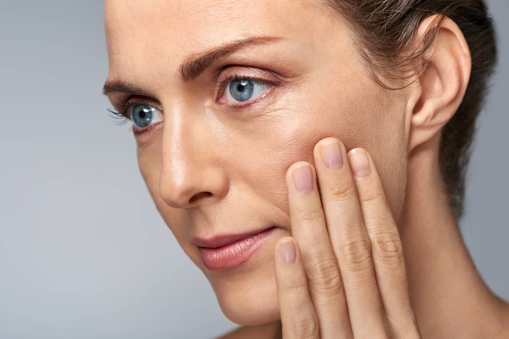 mature woman looking at skin wrinkles