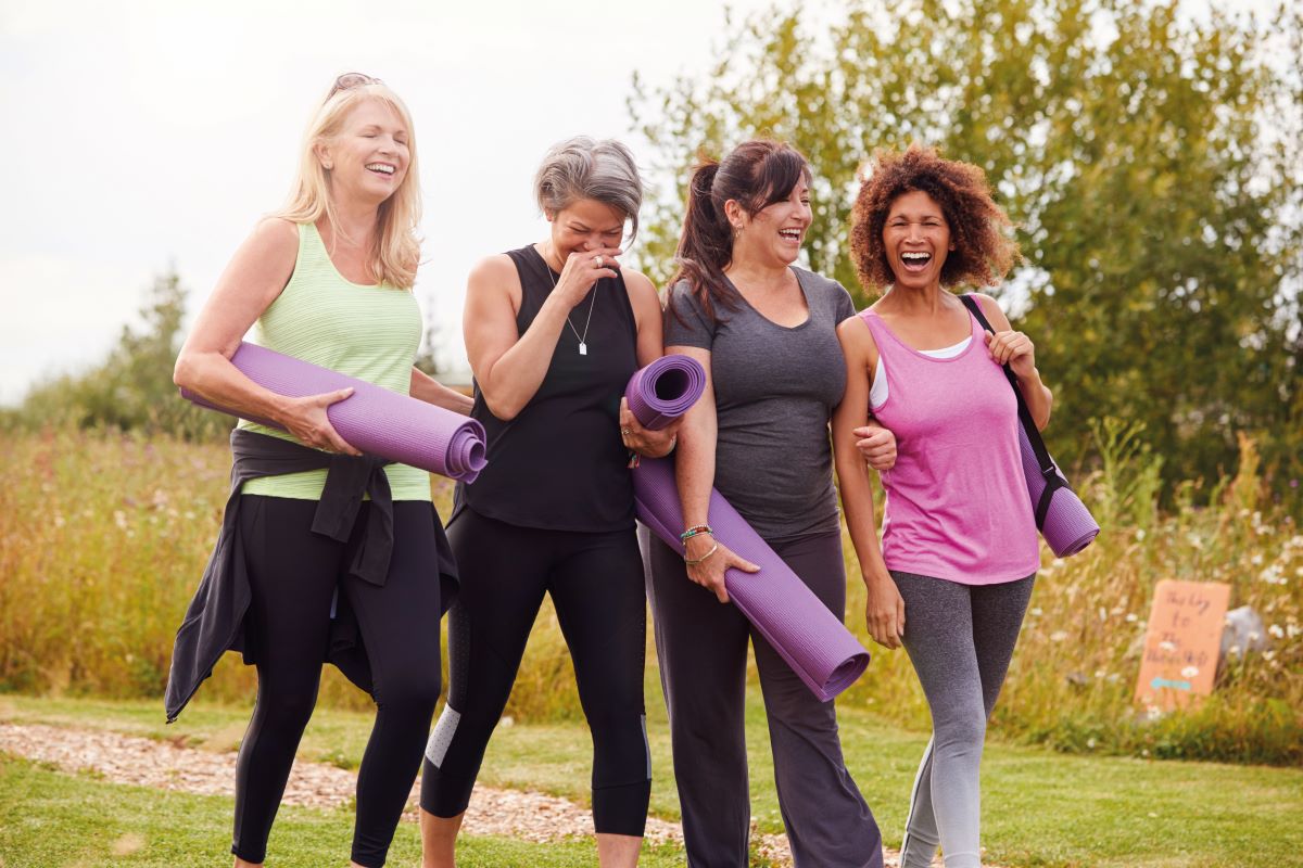 mature group of women walk to yoga class together