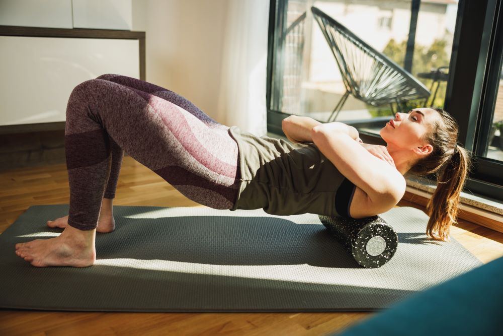 woman using foam roller on back to prevent sports injuries