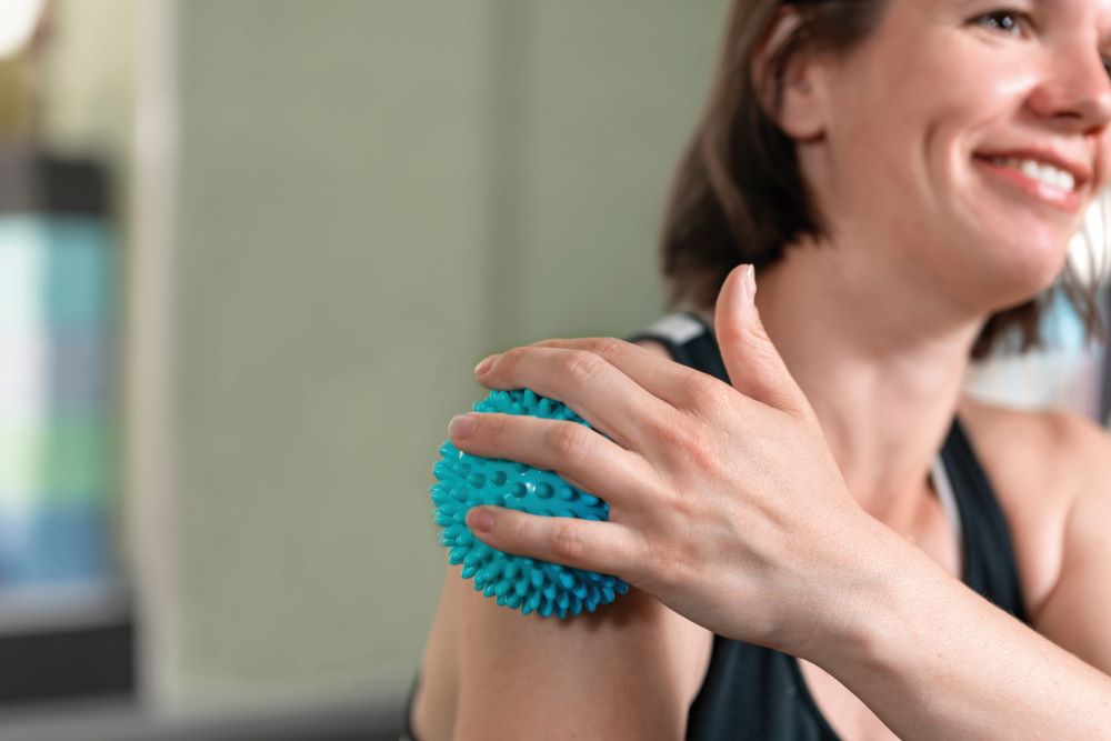woman using self massage ball to prevent sports injuries