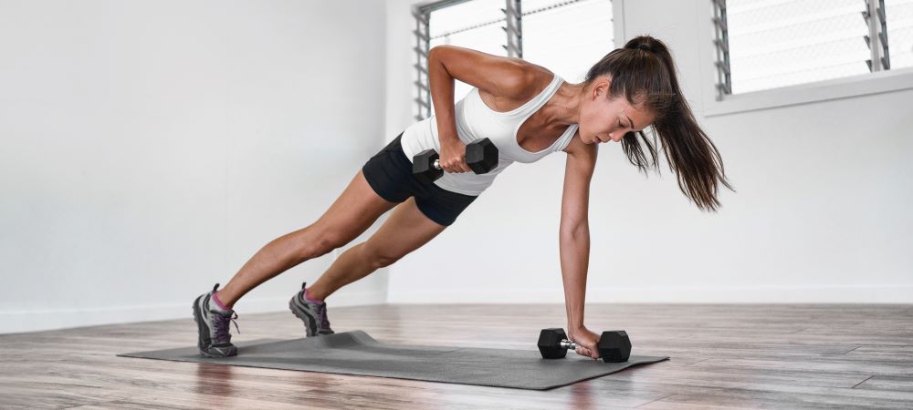 woman demonstrates single arm renegade row