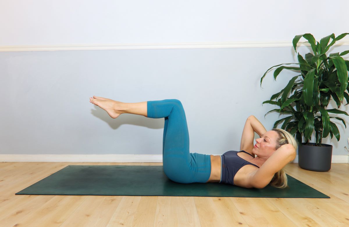 woman demonstrates modified version of slow ab cycle in 12 minute abs workout