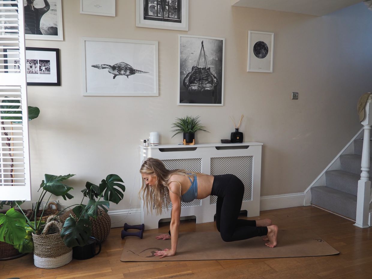 woman demonstrates bear crawl exercise