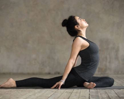 woman demonstrates pigeon pose to open her hips