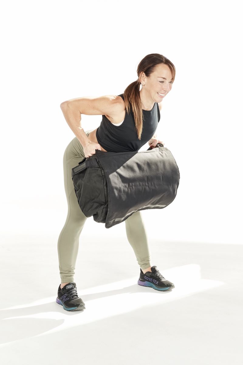 woman demonstrates bent over row, woman demonstrates thrusters, one of the best sandbag exercises