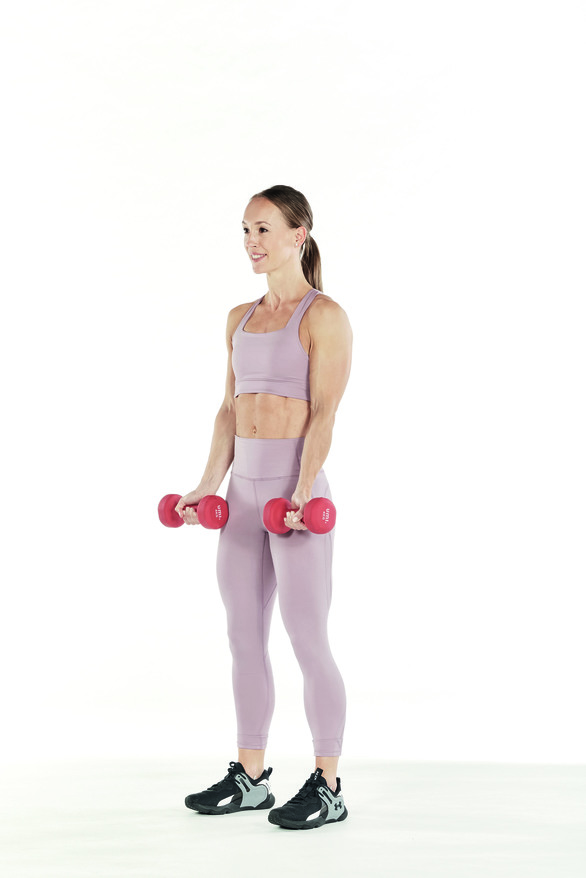 woman demonstrates standing dumbbell curl in arm workout 
