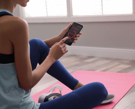woman using free workout app at home fitness on a budget