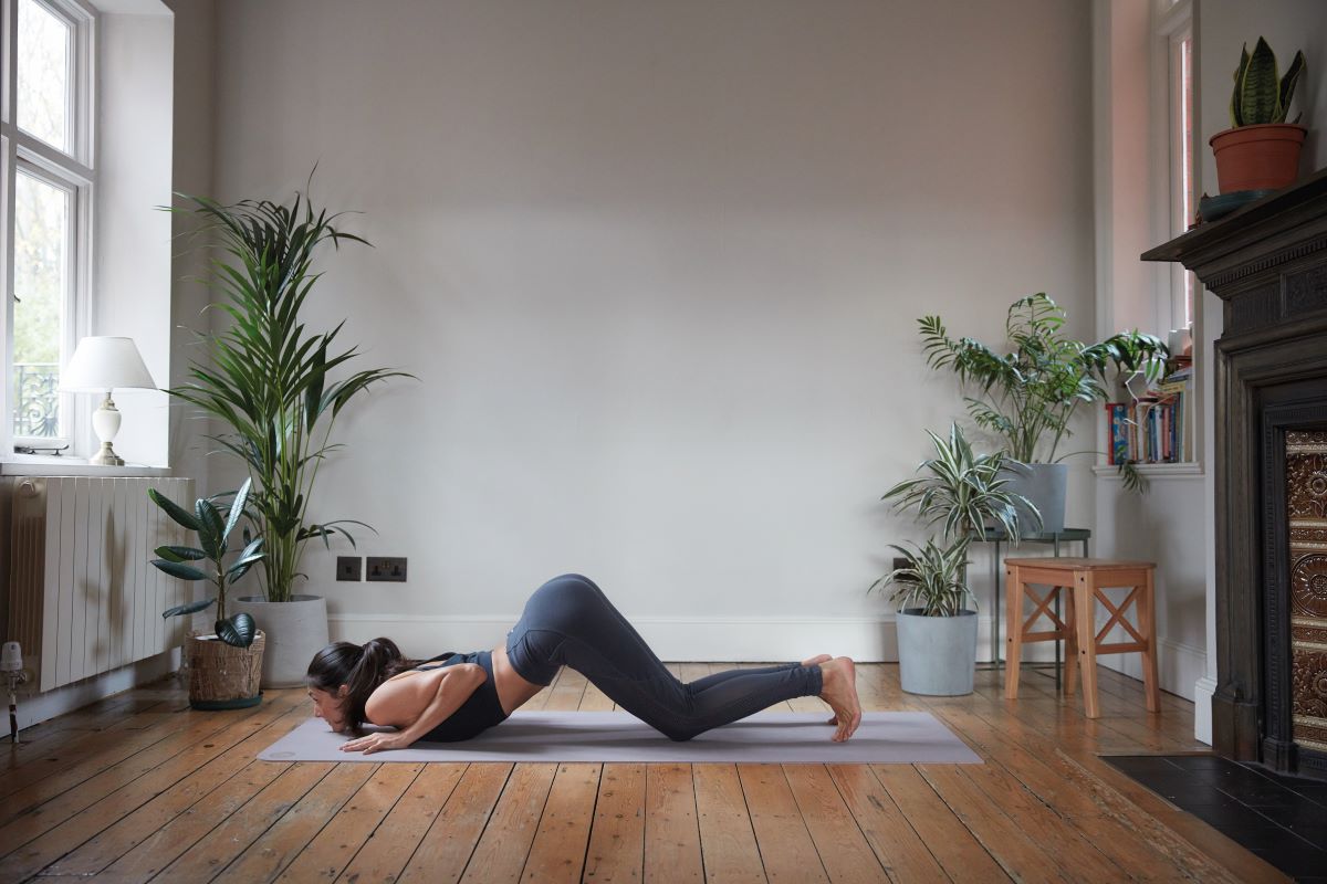woman demonstrating knees chest chin chaturanga yoga self practice routine