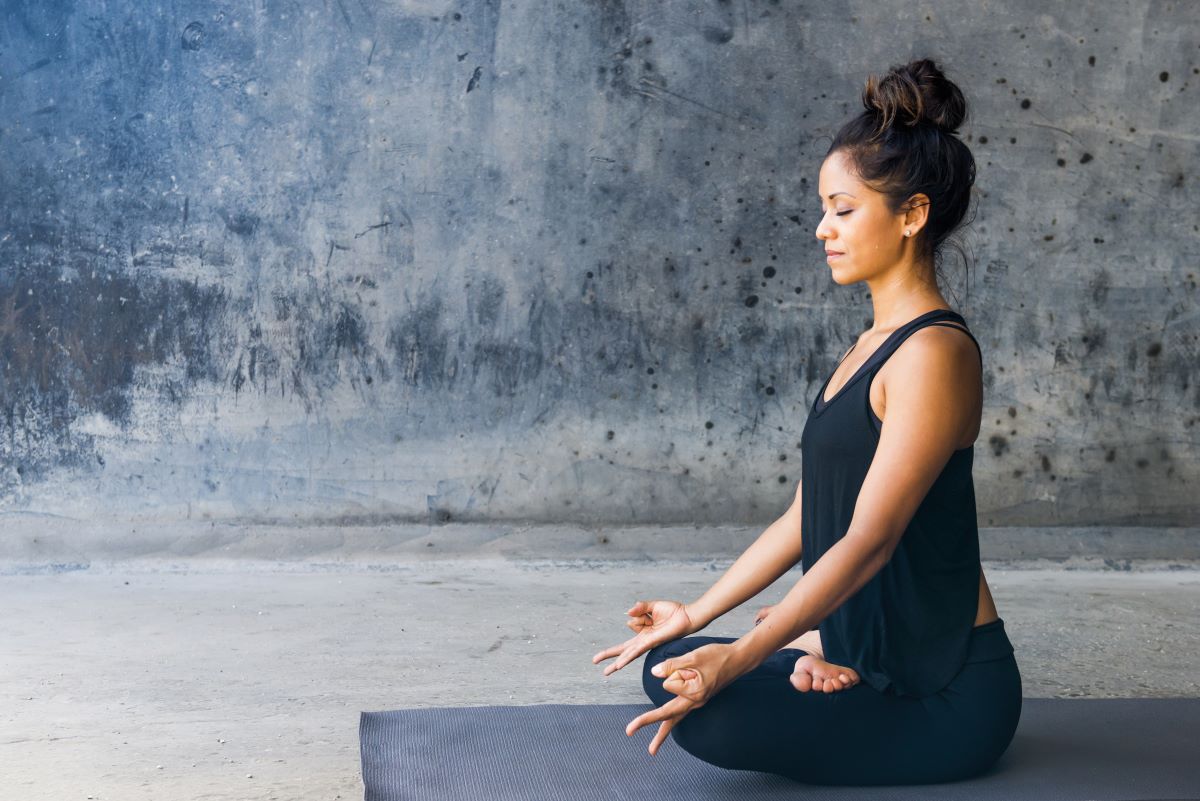 woman meditating on yoga mat