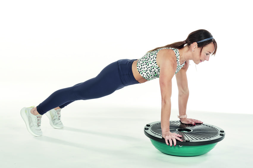 woman demonstrates spiderman crunch on BOSU ball