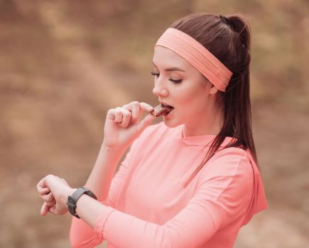 woman eats protein bar nutrition tips for runners