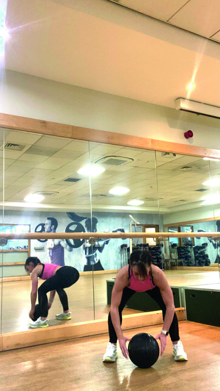 woman demonstrates standing overhead slam 