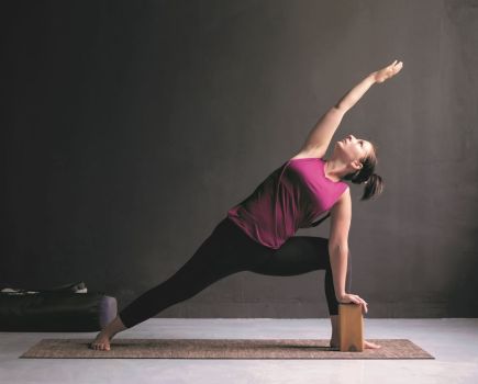 yoga modifications; woman uses a block in extended side angle pose