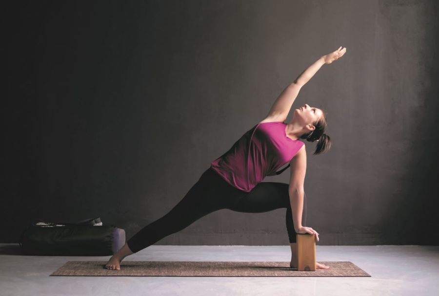 yoga modifications; woman uses a block in extended side angle pose