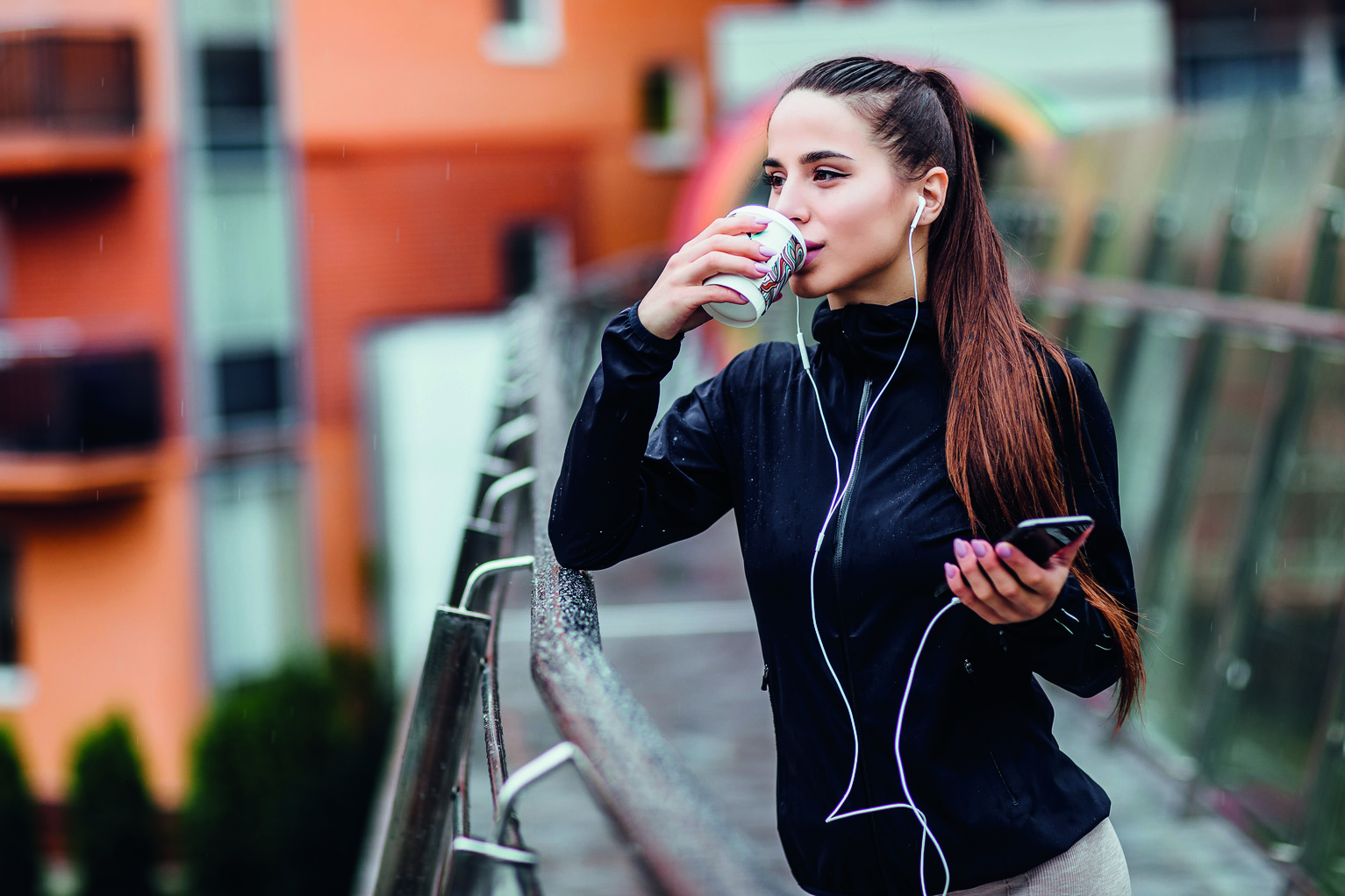 woman drinks coffee while on run