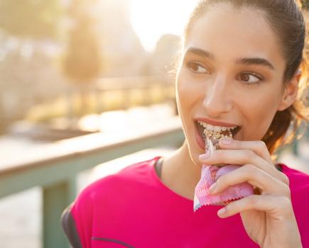 woman eating protein bar close up