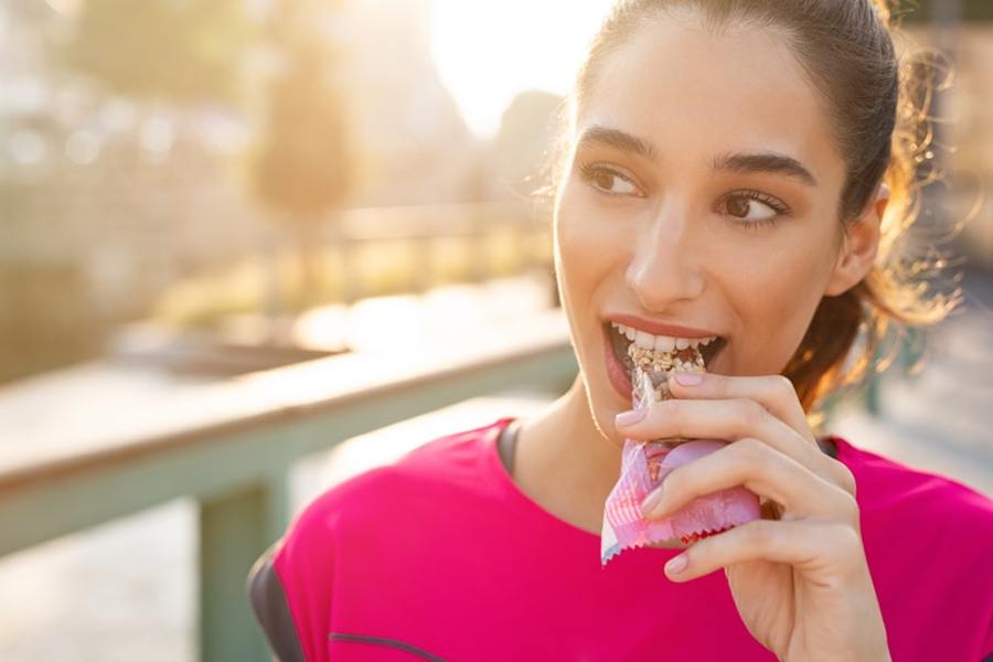 woman eating protein bar close up