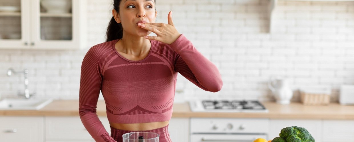 woman making smoothie licking fingers