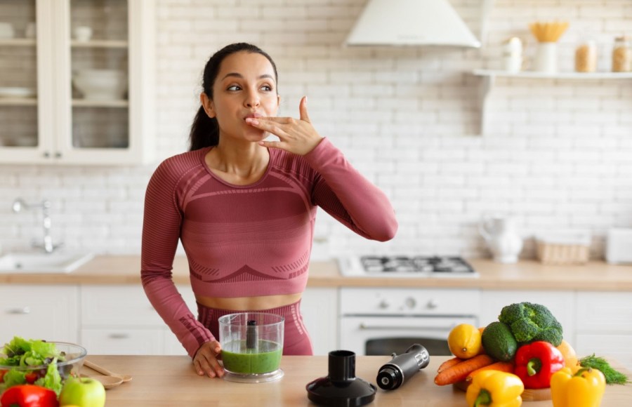 woman making smoothie licking fingers