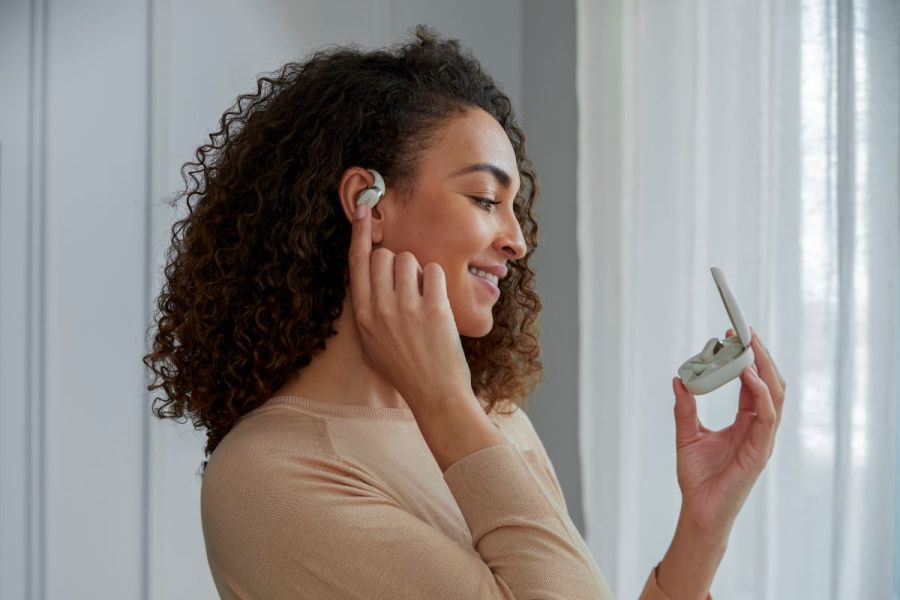 woman models the shokz openfit earphones
