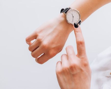 woman looking at watch, find time to exercise