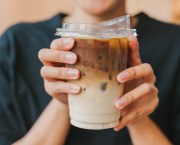 woman holding iced coffee drink in summer