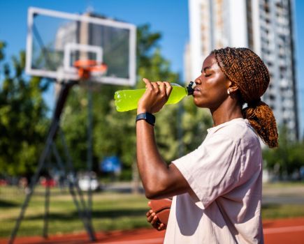 woman drinking sports drink outside