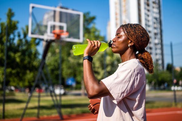 woman drinking sports drink outside