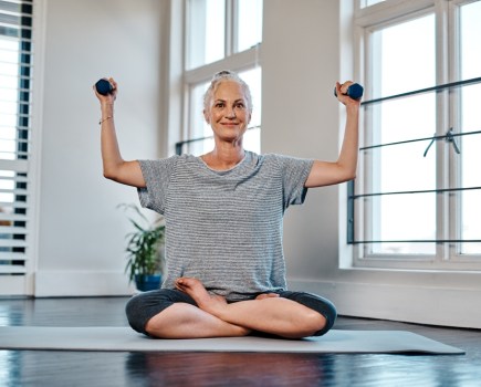 woman practising yoga with weights