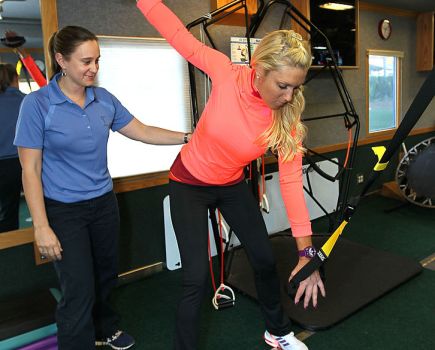 Woman using pull machine at gym