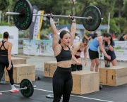 A woman lifts a barbell overhead