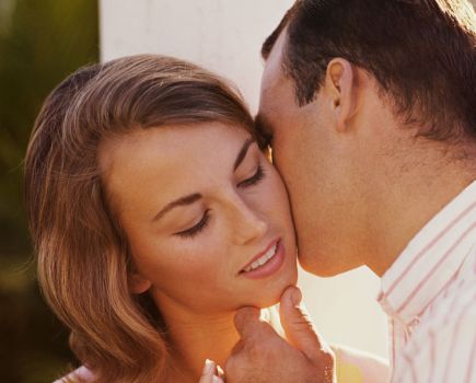 Man kissing woman's face