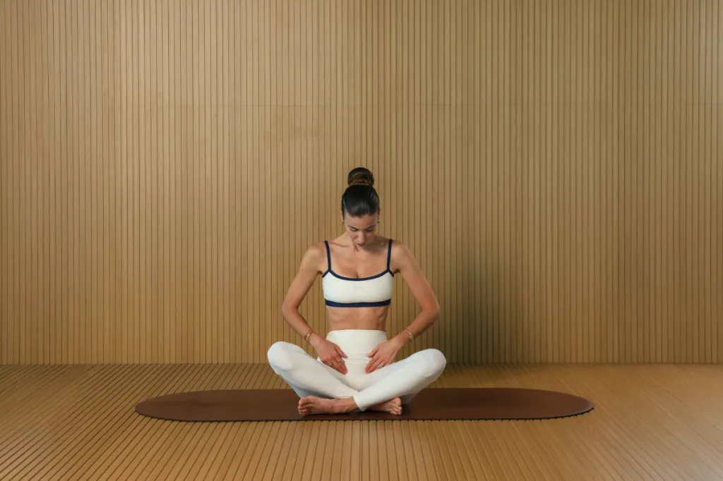 woman doing lymphatic tapping warm-up tapping her belly and groin area