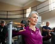 midlife woman strength training using resistance machine in the gym, she adapts workouts for menopause and beyond