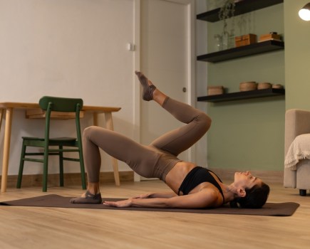 woman at home pilates workout for lymphatic drainage and reducing bloating