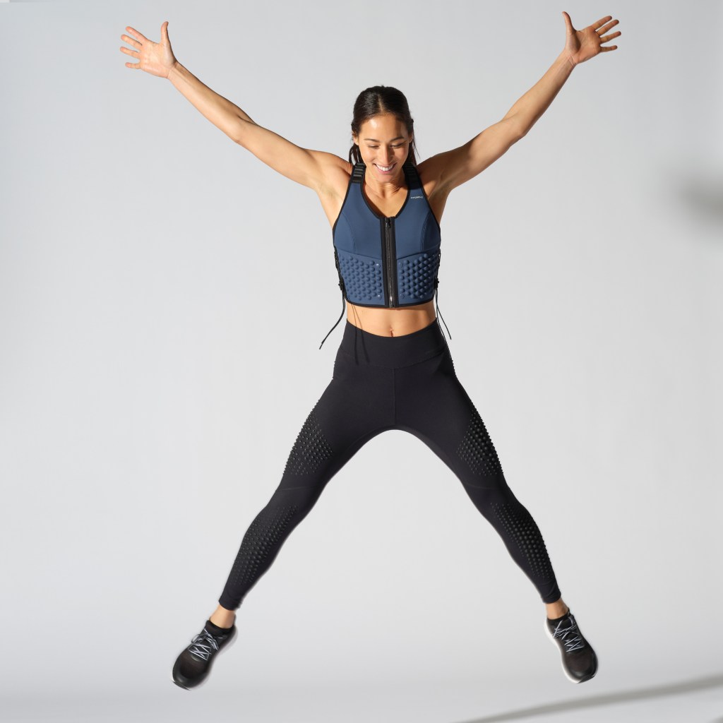 woman doing star jumps while wearing the OMORPHO G-Vest Icon