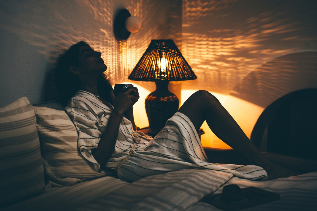Young woman relaxing during coffee time in bed.