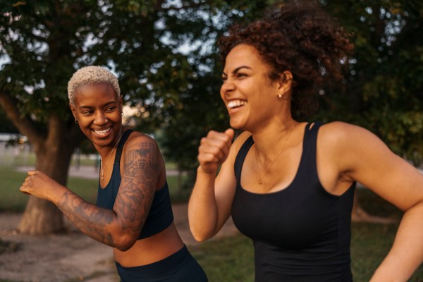Determined woman competing each other while running at park