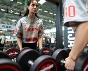 A woman choosing weights in a gym