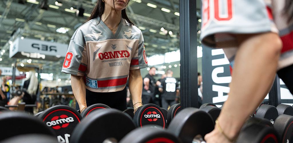 A woman choosing weights in a gym